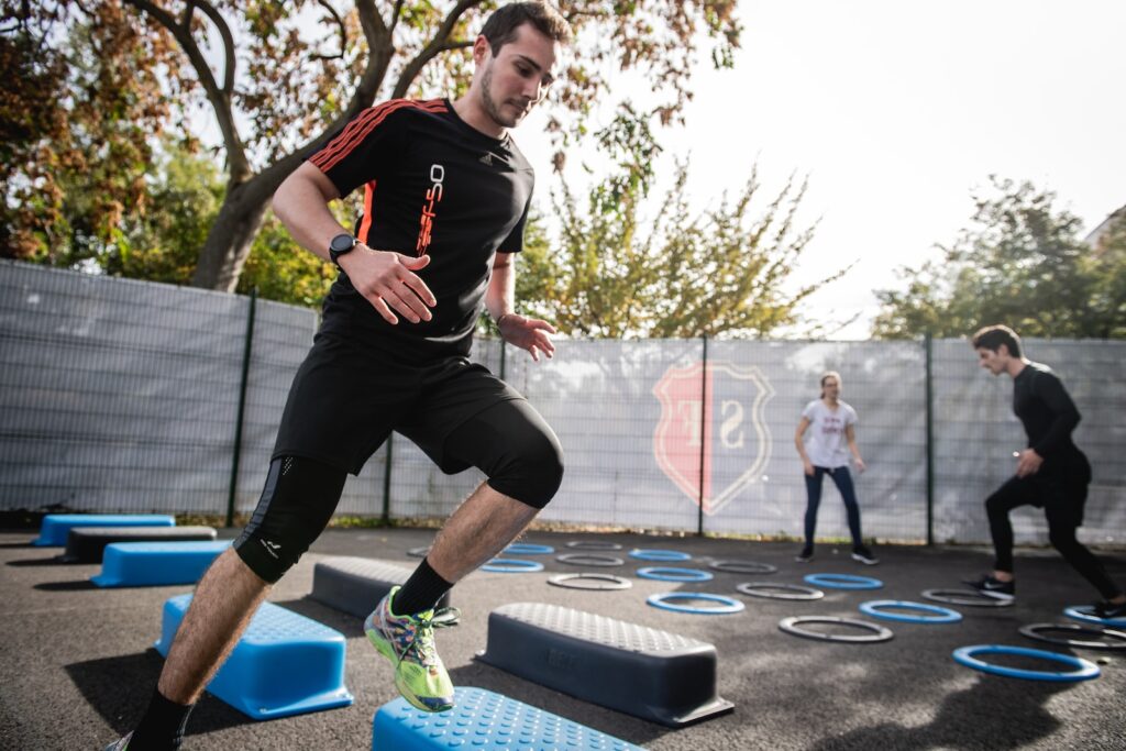 man in black crew neck t-shirt and black shorts running on blue and white trampoline