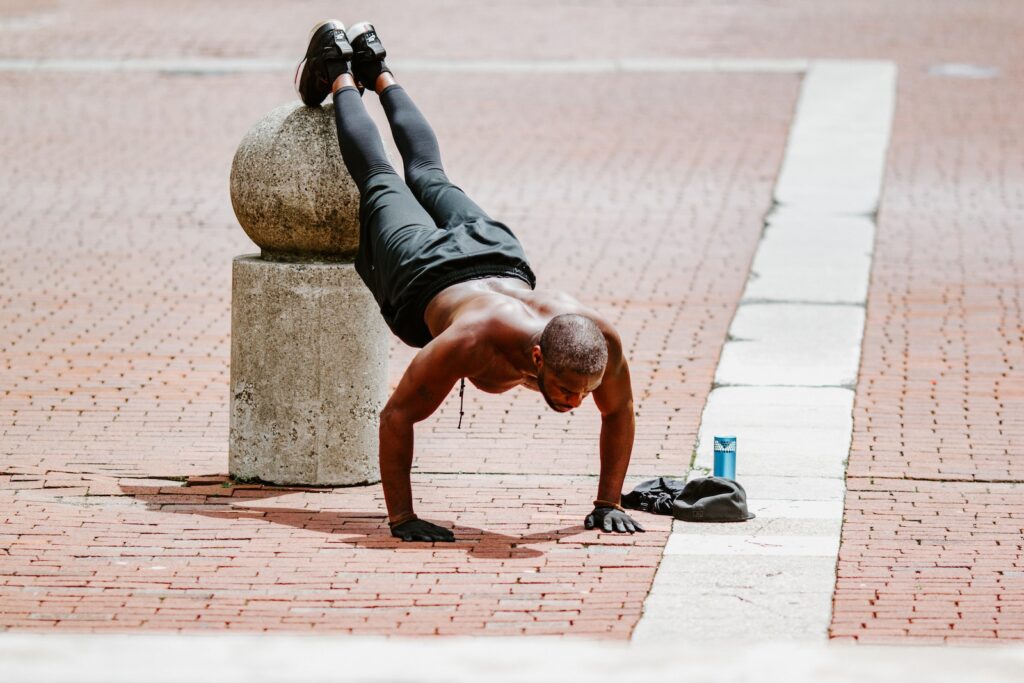 man in black tank top and black shorts lying on brown concrete floor during daytime